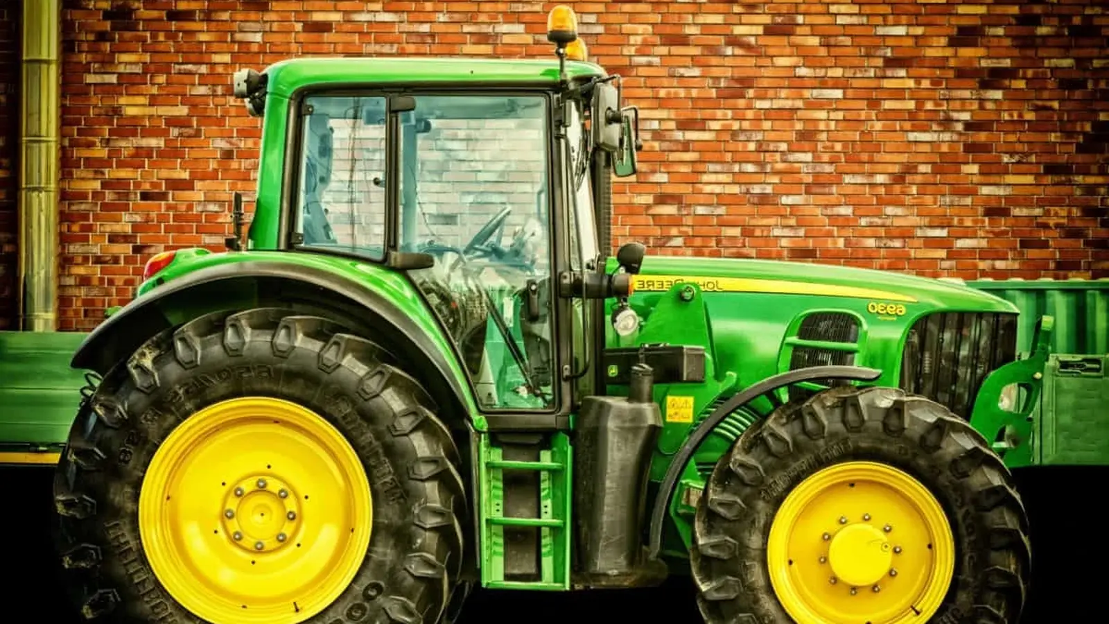 Tractor pulling a mounted implement with hydraulic lines running to the rear outlets