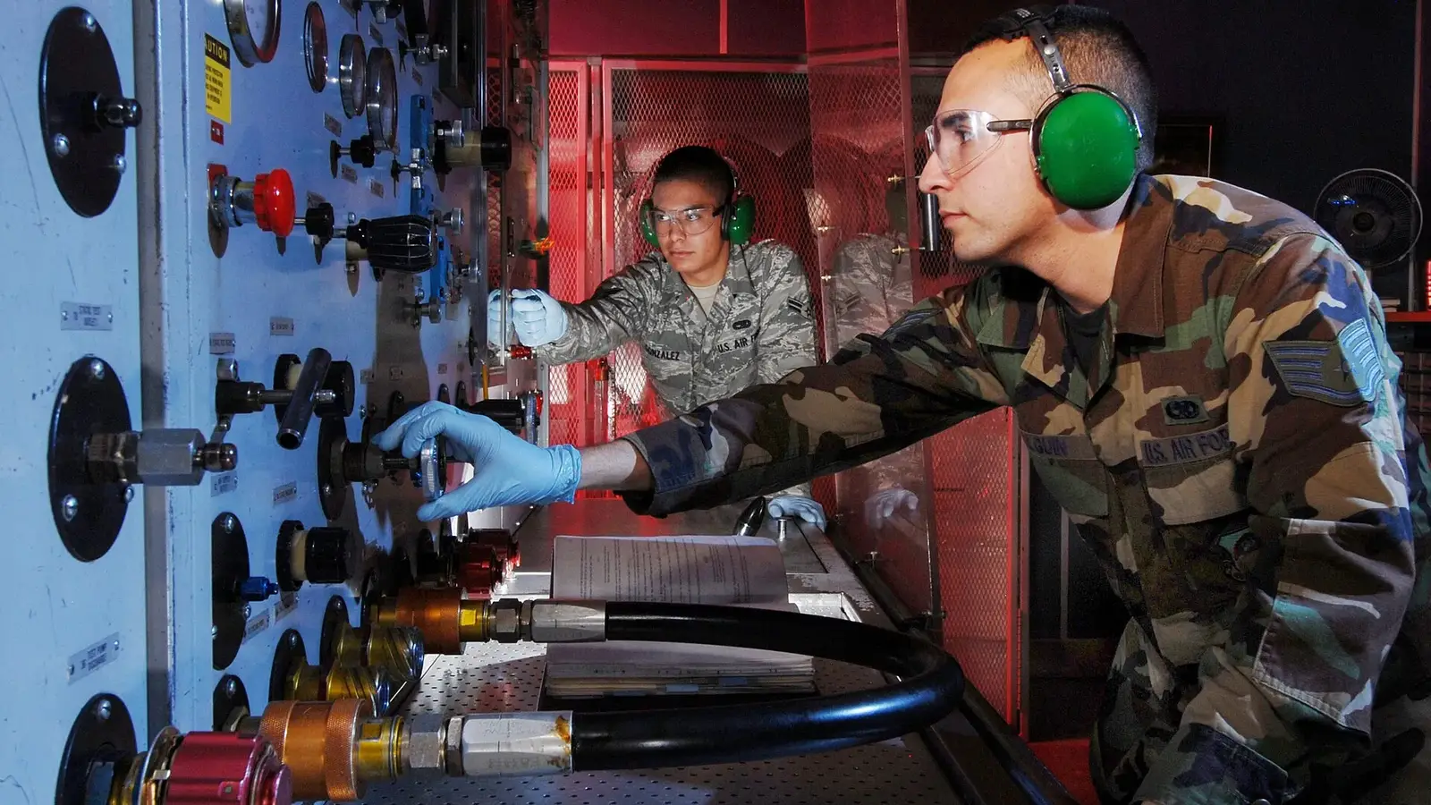 Technicians inspecting a hydraulic test stand during a pressure check